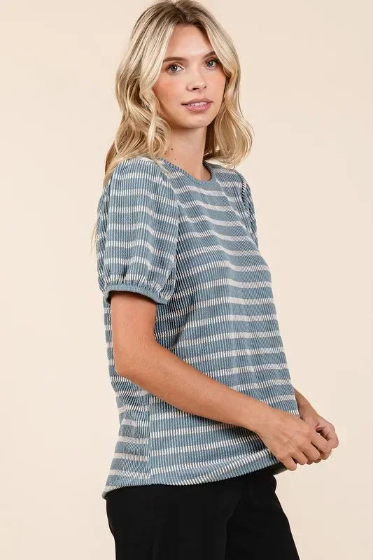 Woman wearing a blue and white striped short sleeve blouse with relaxed fit
