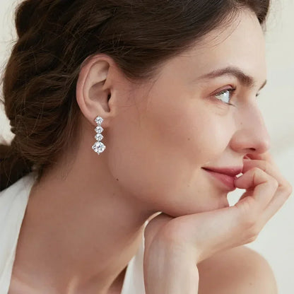 Woman with braided hair wearing elegant cubic zirconia drop earrings
