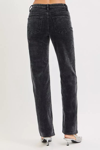 Back view of straight-leg black corduroy pants with high waist and two pockets, styled with heels