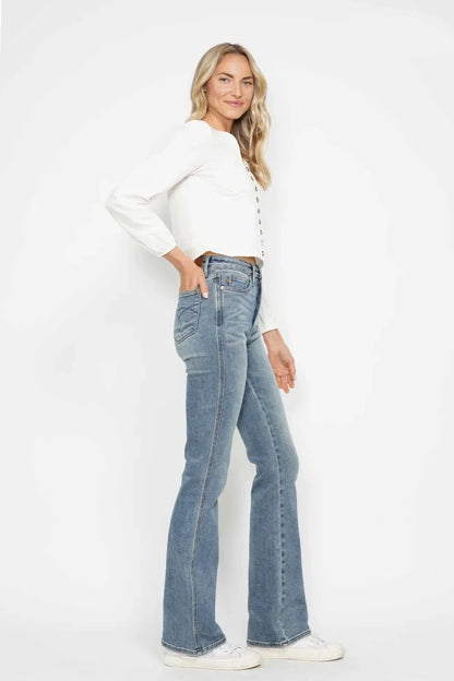 Woman in white button blouse and high-waisted flared jeans with white sneakers