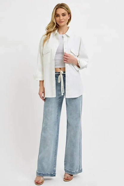Woman wearing relaxed white button-up shirt and wide-leg light blue jeans, casual outfit