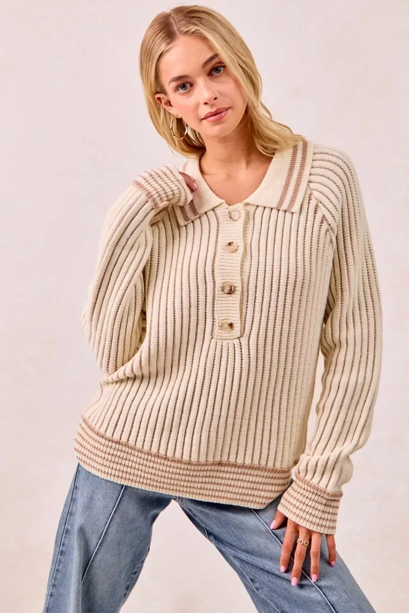 Woman wearing a cream ribbed knit sweater with button collar and relaxed fit, paired with jeans.
