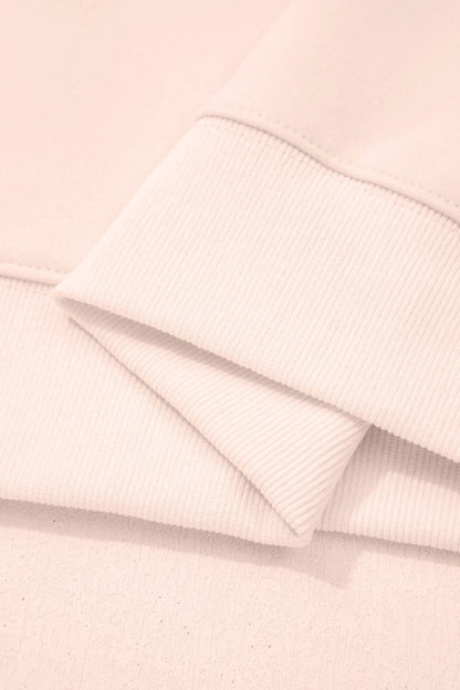 Close-up of soft pink ribbed knit fabric cuffs with a relaxed, modern style
