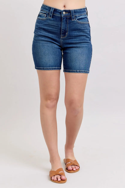 High-rise denim bermuda shorts with rolled hem, styled with tan slide sandals