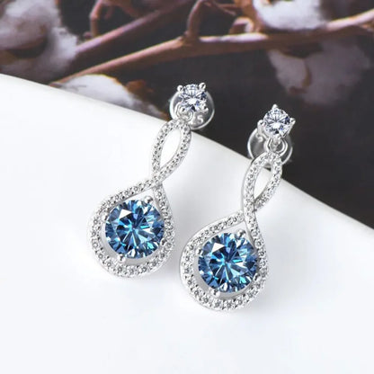 Elegant silver drop earrings with blue gemstones and sparkling crystal accents on white background