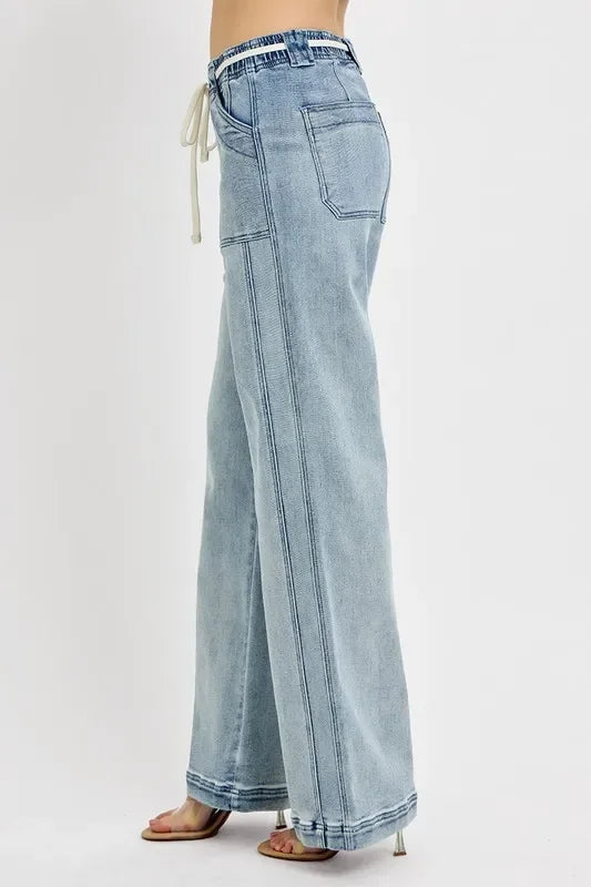 Side view of woman in light wash wide-leg jeans with drawstring waist and front pockets