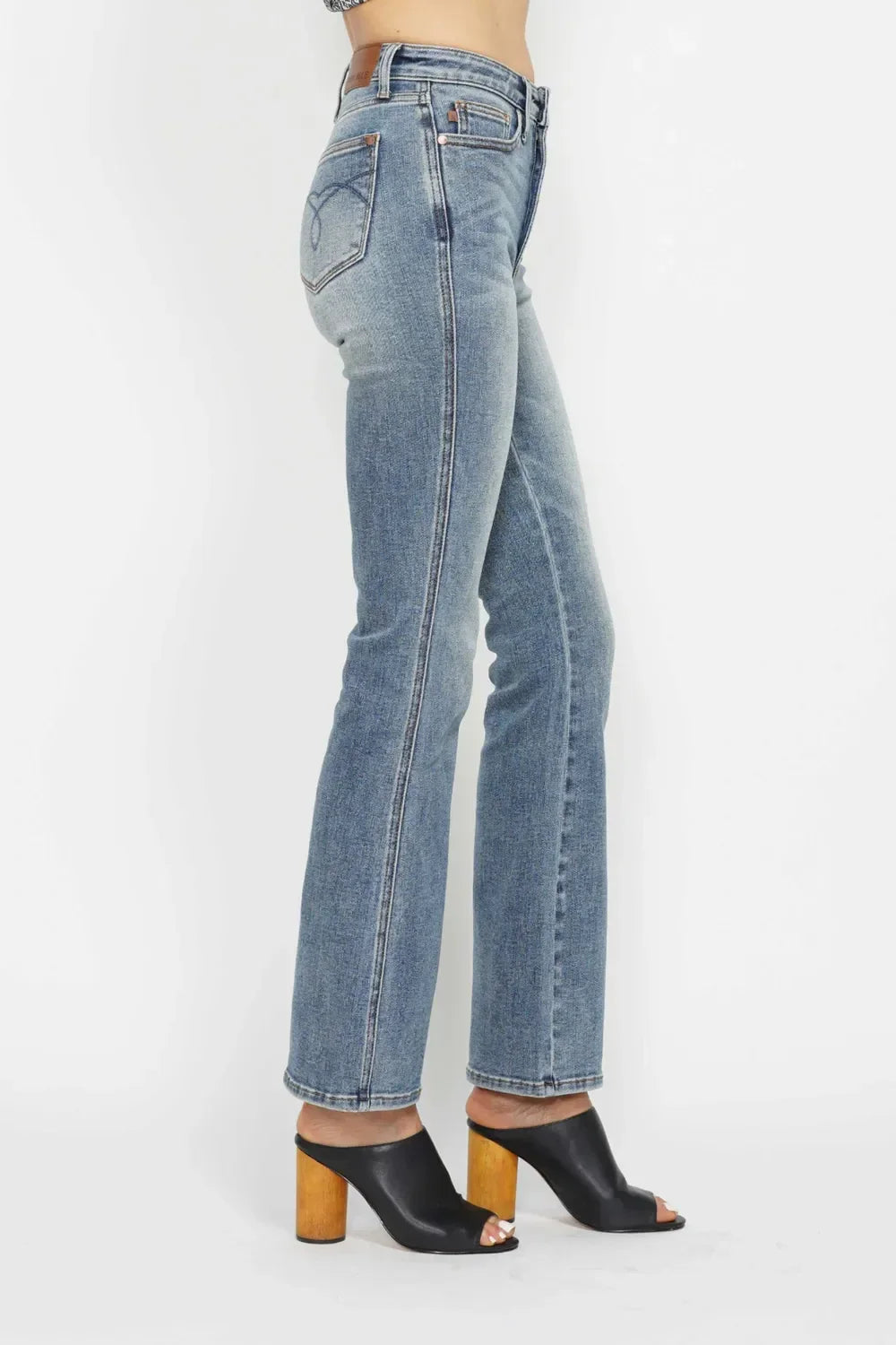Woman wearing high-waisted straight leg blue jeans and black heeled sandals