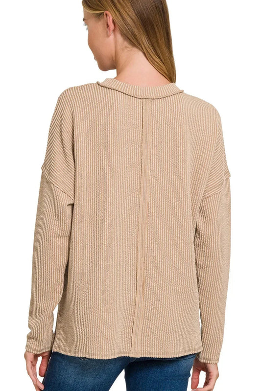 Back view of woman wearing light mocha ribbed long sleeve top with relaxed fit