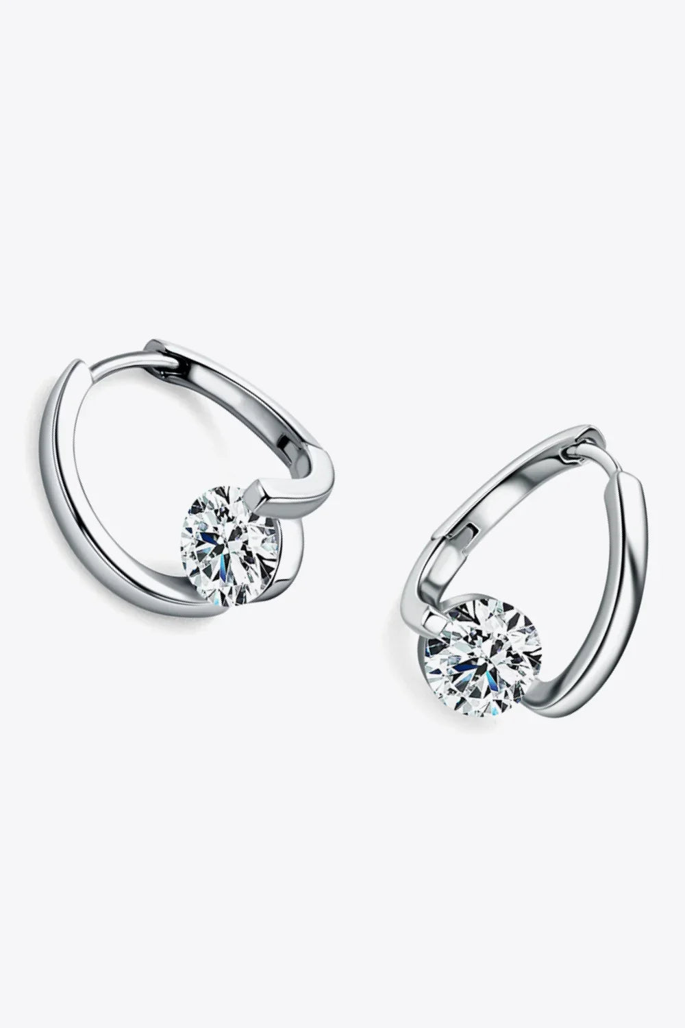 Silver hoop earrings with round, clear gemstone accents on a light background