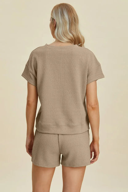 Woman wearing taupe textured short-sleeve lounge set with geometric knit pattern, back view