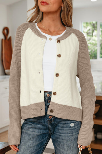 Woman wearing a two-tone knit cardigan with beige sleeves and cream front, paired with jeans