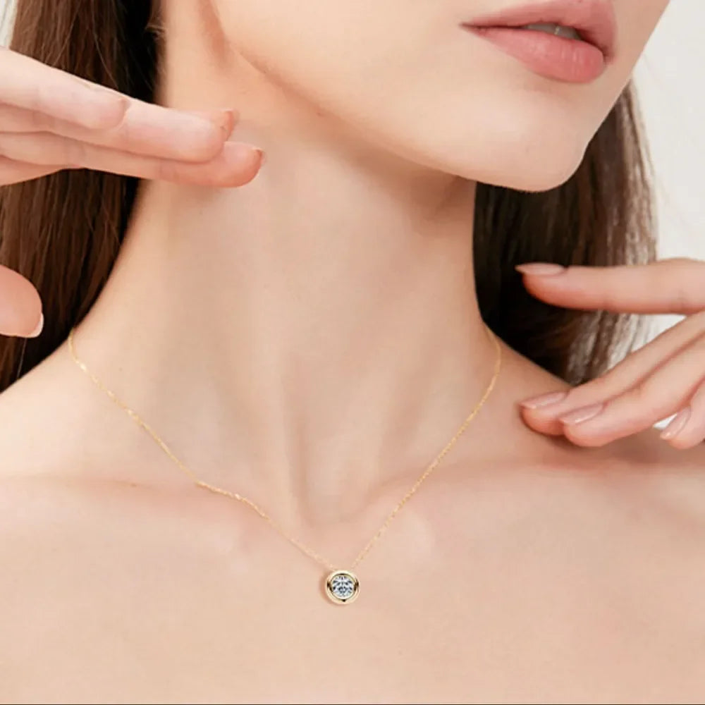 Model wearing a delicate gold pendant necklace with minimalist design details