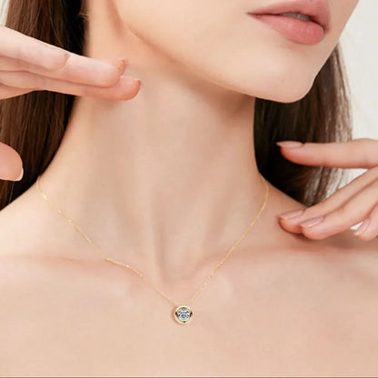 Model wearing a delicate gold pendant necklace with minimalist design details