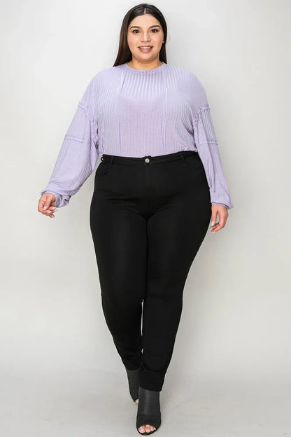 Woman wearing a lavender ribbed blouse with black skinny pants and open-toe heels.