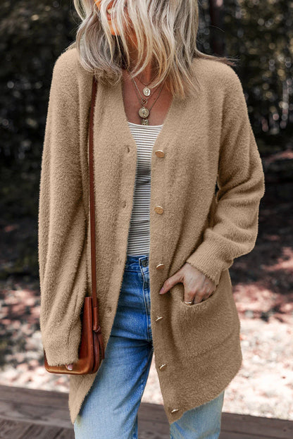 Woman in a cozy camel button cardigan, striped top, blue jeans, and brown crossbody bag outdoors