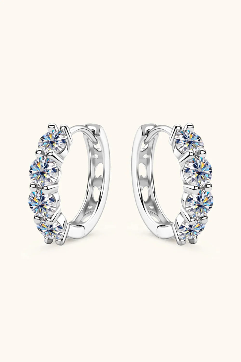 Silver hoop earrings with five round-cut clear gemstones set in a row on a neutral background.