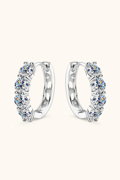 Silver hoop earrings with five round-cut clear gemstones set in a row on a neutral background.