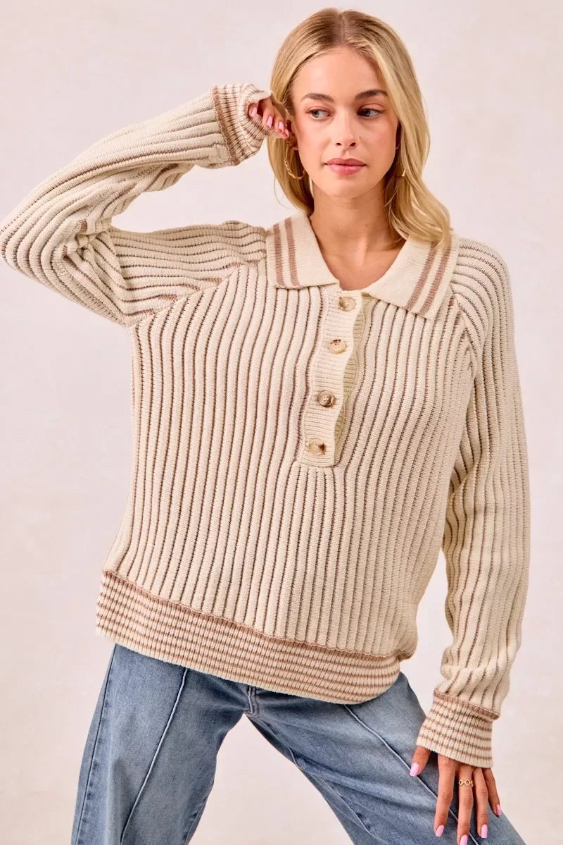 Woman wearing a cream ribbed knit sweater with buttons and collar, paired with blue jeans