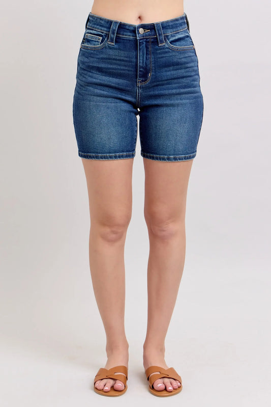 High-waisted medium wash denim shorts with front pockets, styled with tan sandals