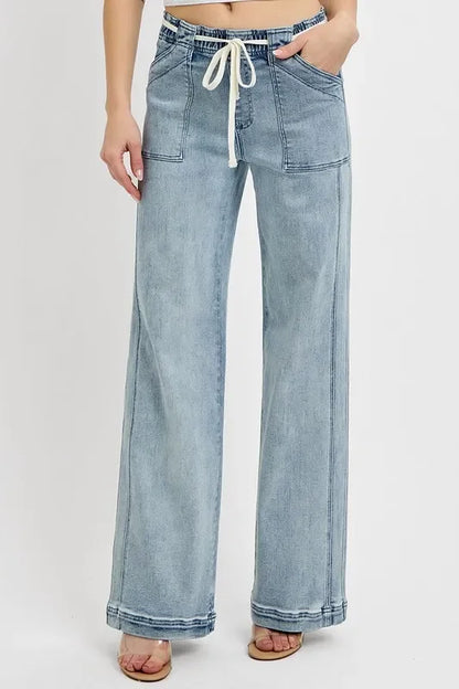 Wide-leg light wash denim pants with front patch pockets and drawstring waist, shown on model.