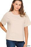 Woman wearing a sand beige short-sleeve relaxed fit t-shirt with blue jeans