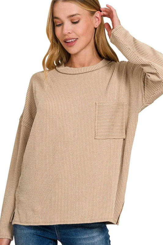 Woman wearing a light mocha ribbed knit long sleeve top with chest pocket and relaxed fit.