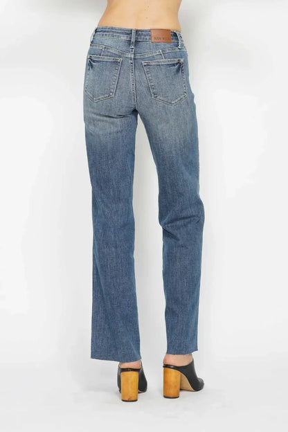Back view of straight leg blue jeans with back pockets and brown heeled mules