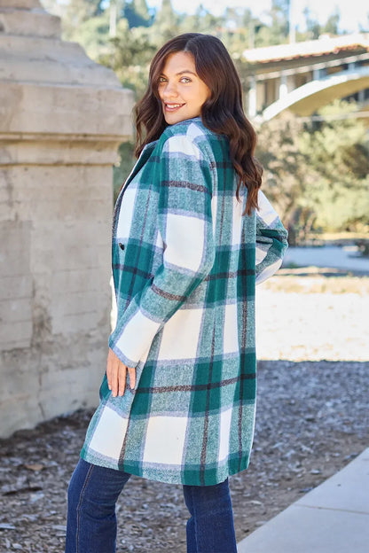 Woman wearing a green and white plaid coat with blue jeans outdoors