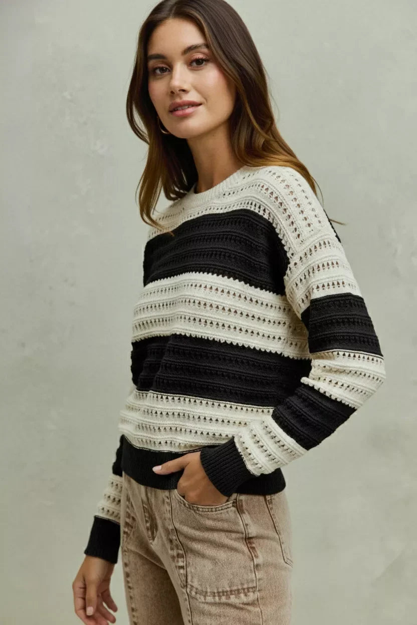 Woman wearing a black and white striped knit sweater with relaxed beige jeans.