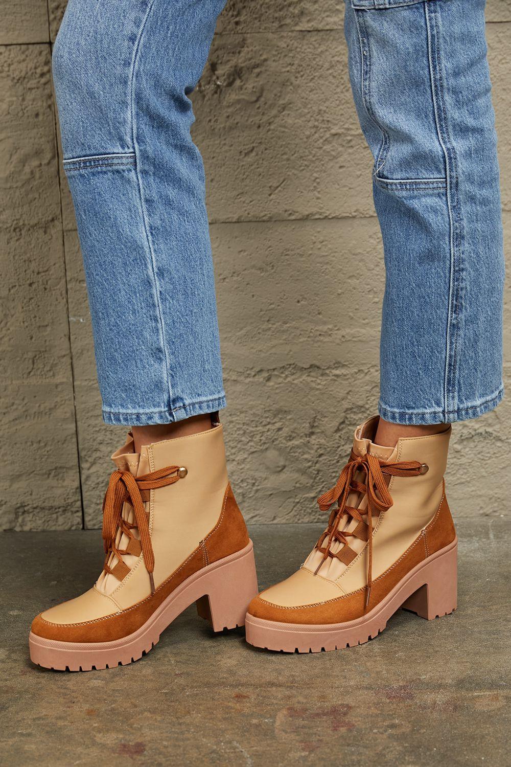 Tan and brown lace-up heeled boots styled with blue denim jeans, chunky lug sole design