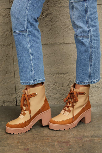Tan and brown lace-up heeled boots styled with blue denim jeans, chunky lug sole design