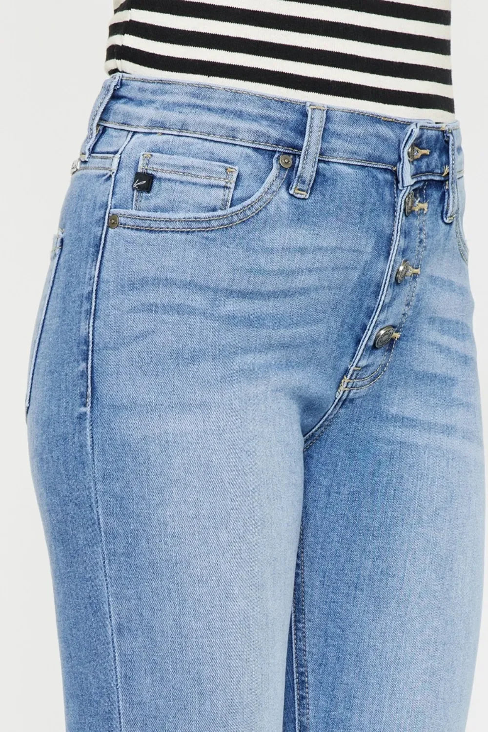 Light wash high-rise jeans with button fly and front pockets, paired with striped top.