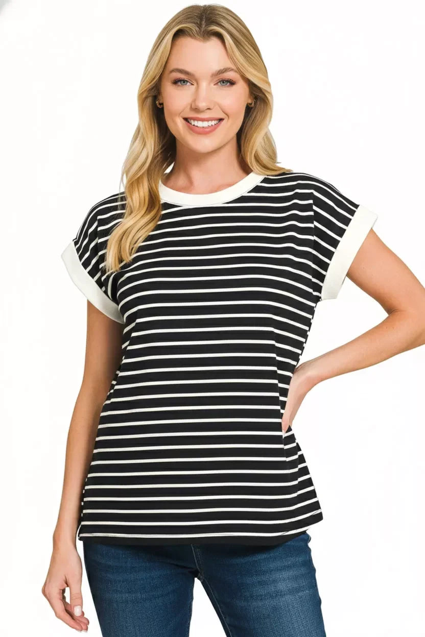 Woman wearing a black and white striped short sleeve top with white trim and blue jeans