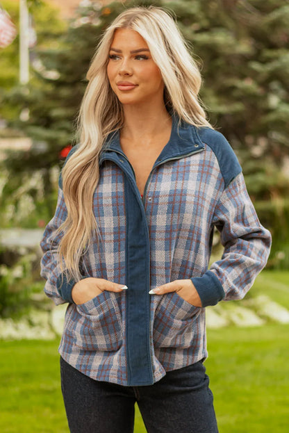 Woman wearing a blue plaid zip-up jacket with corduroy collar and cuffs outdoors