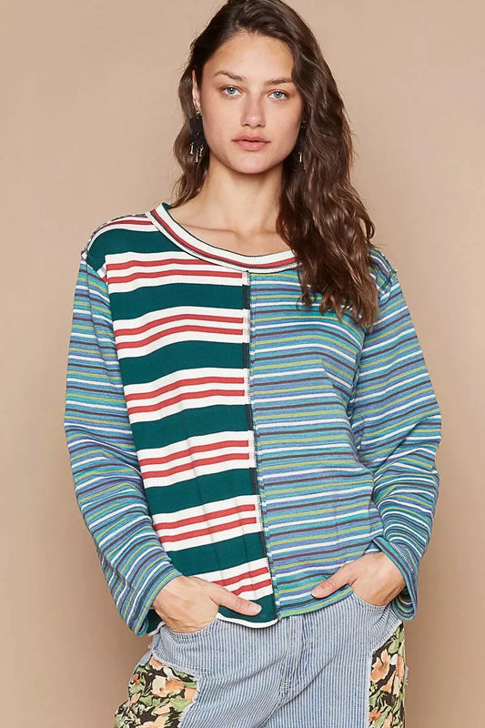 Woman wearing a relaxed fit, striped colorblock long sleeve top and casual patchwork pants.