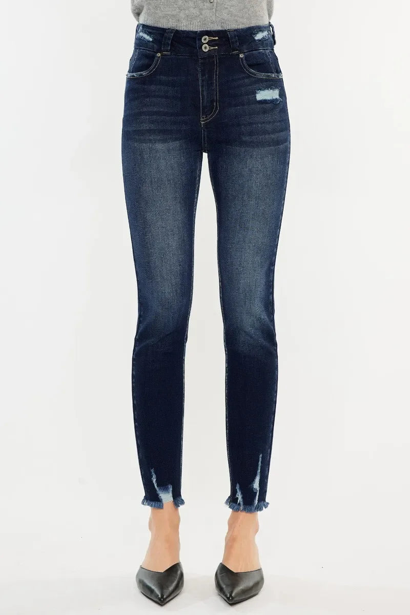 High-rise distressed skinny jeans with frayed hems and faded dark blue wash, front view.