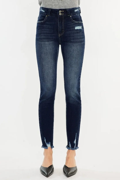 High-rise distressed skinny jeans with frayed hems and faded dark blue wash, front view.