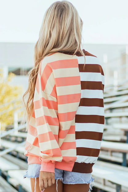 Woman wearing relaxed striped long-sleeve pullover in peach and brown tones outdoors