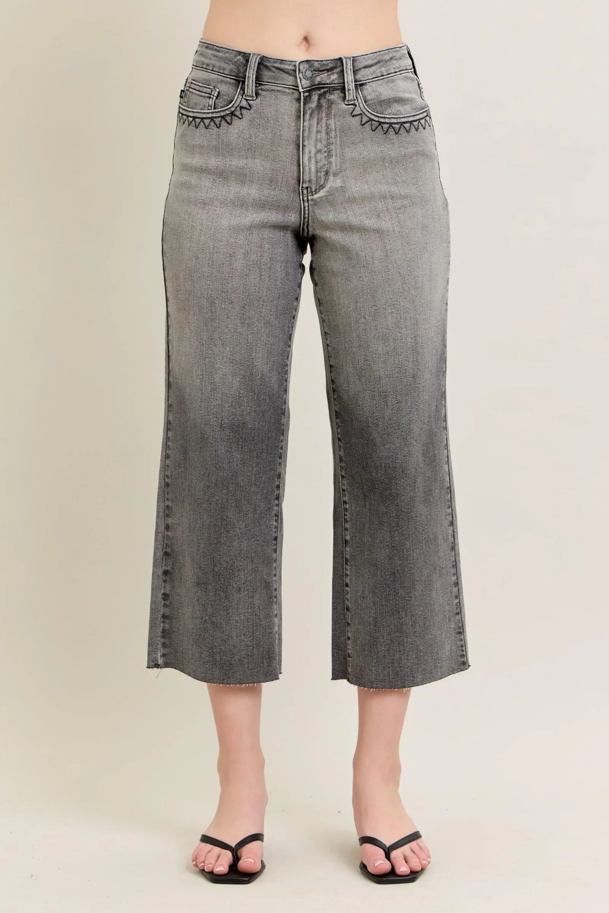 High-waisted gray wide-leg jeans with embroidered details and raw hems, front view