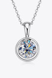 Silver chain necklace with round bezel-set clear gemstone pendant on white background