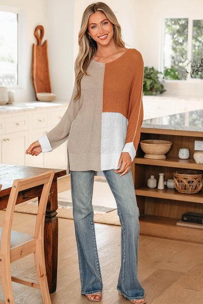 Woman wearing a colorblock knit sweater and blue jeans in a modern kitchen setting