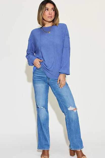 Woman wearing a blue ribbed long-sleeve top with relaxed fit jeans and heeled sandals