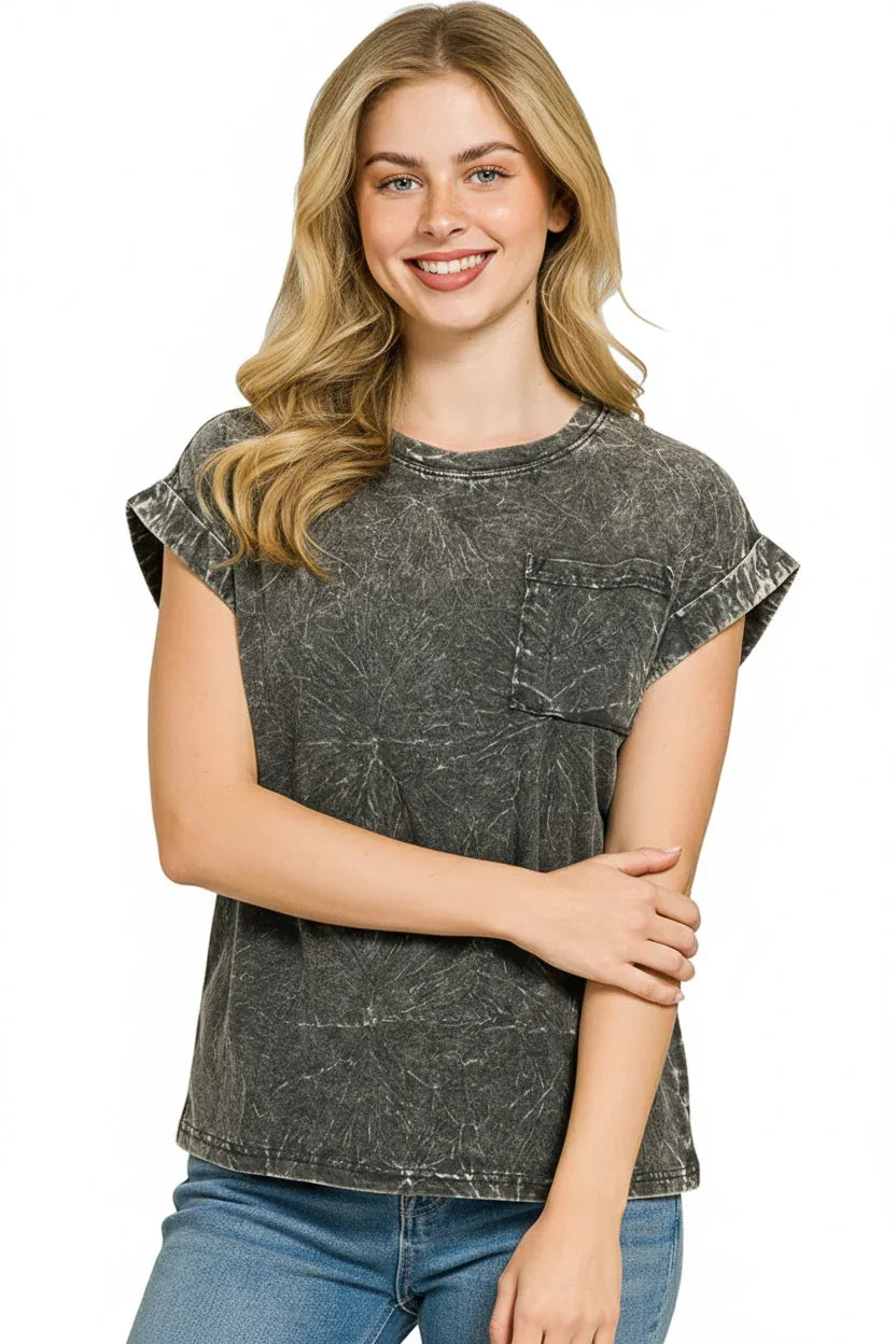 Woman wearing a black acid wash short sleeve t-shirt with front pocket and light blue jeans