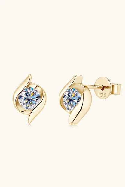 Gold stud earrings with round clear gemstones and modern leaf-inspired design on neutral background.