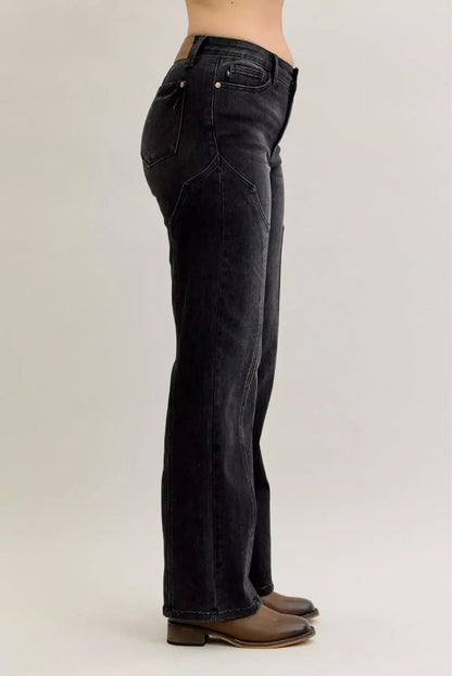 Side view of a woman wearing high-waisted black straight-leg jeans and brown boots
