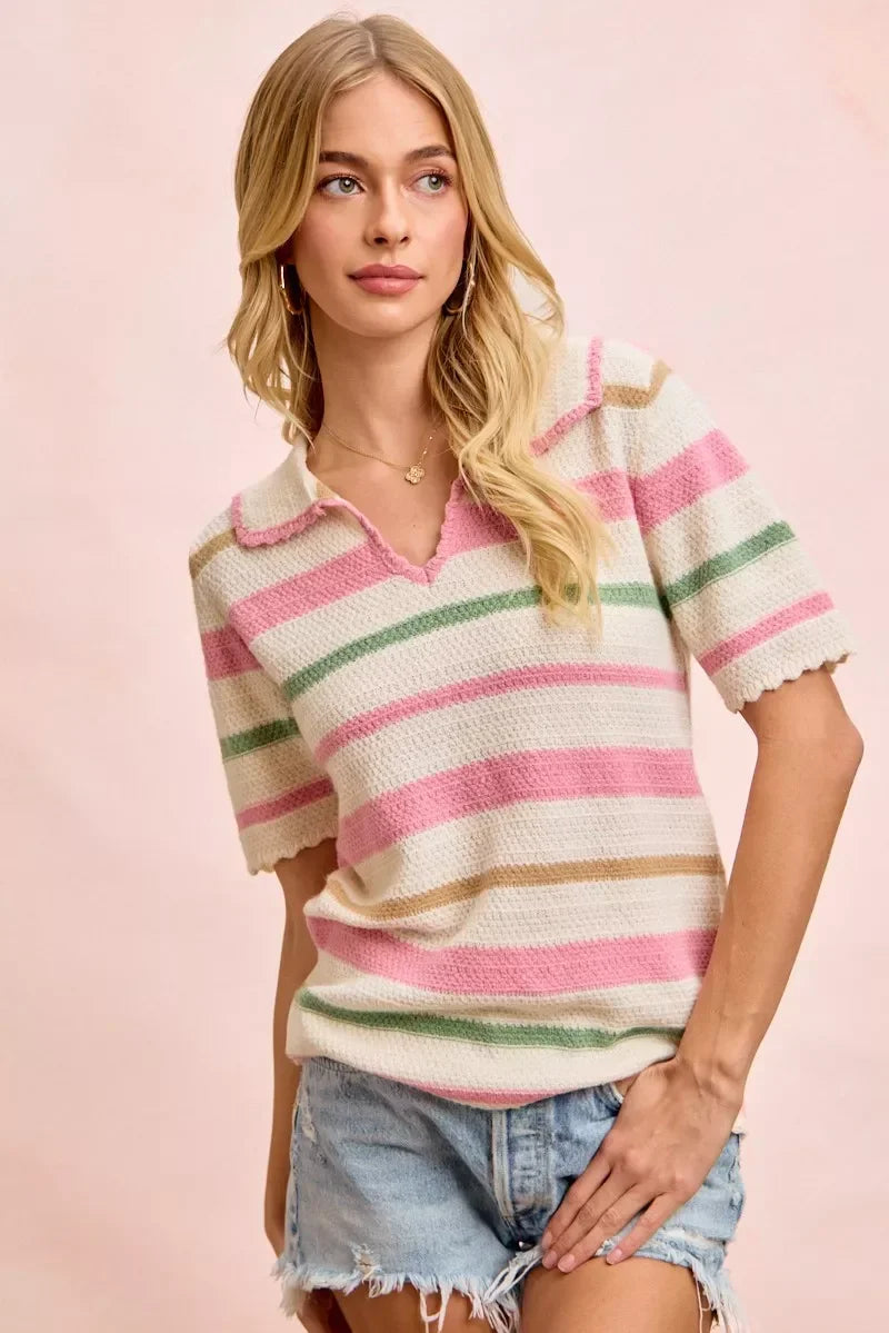 Woman wearing a pink, green, and beige striped knit polo top with light denim shorts.