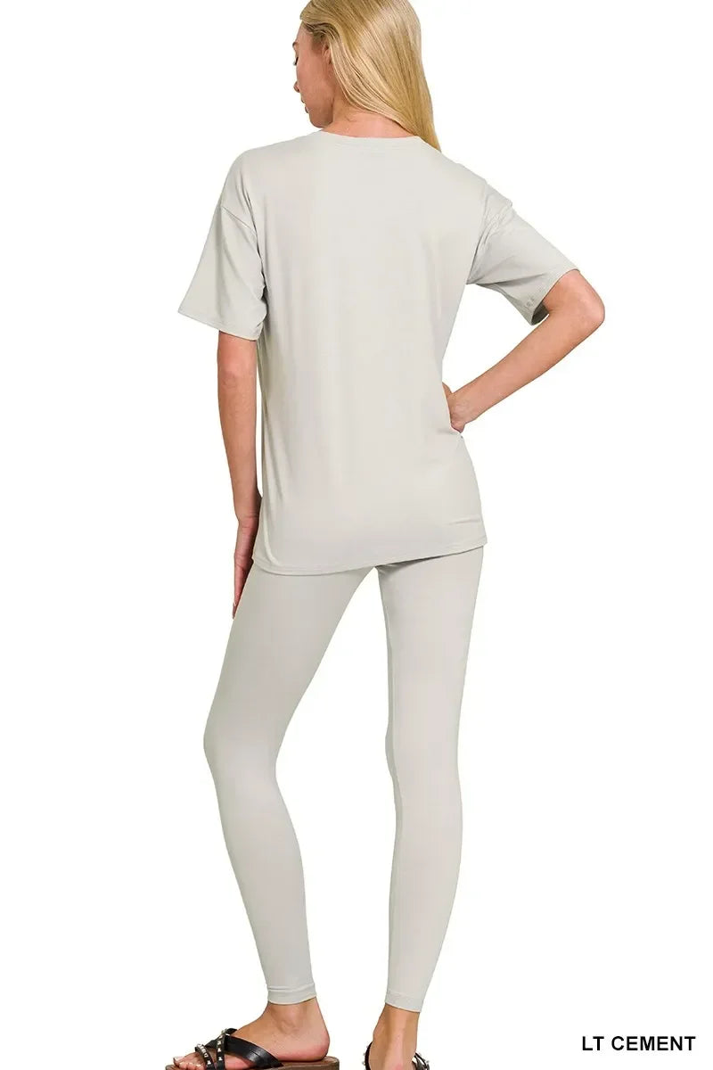 Woman wearing light cement short sleeve top and matching leggings, back view.