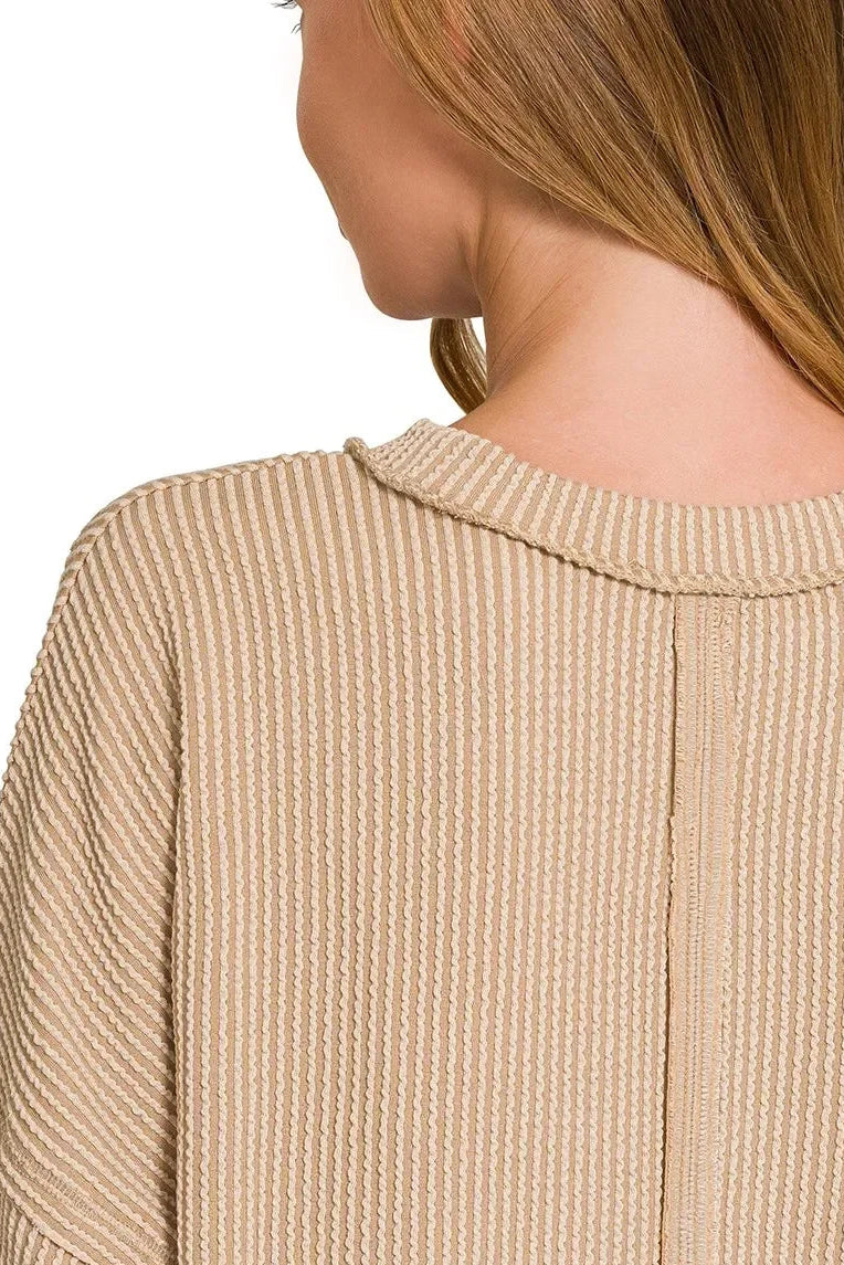 Back view of woman wearing light mocha ribbed knit sweater with relaxed fit