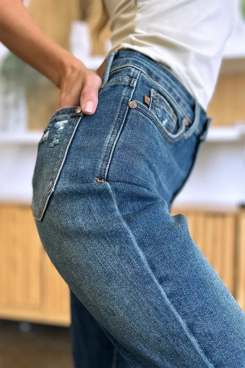 Close-up of woman wearing high-rise blue denim jeans with slight distressing