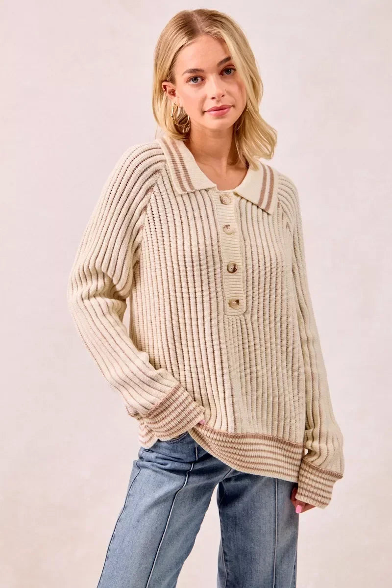 Woman wearing a cream ribbed knit sweater with collar and front buttons, paired with jeans.